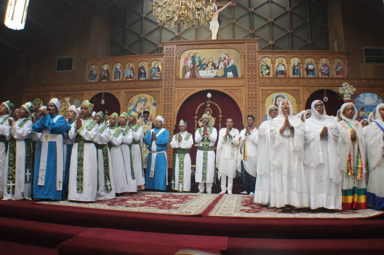 Choir and clergy standing in prayer before the sanctuary