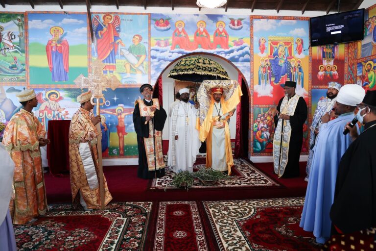 Clergy gathered in the sanctuary before the painted icons